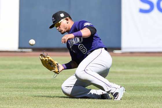 Gerardo Parra of the Colorado Rockies attempts to field a ball during spring training.