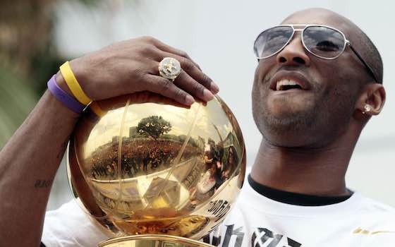 Kobe Bryant holds the NBA championship trophy during a downtown parade in Los Angeles.